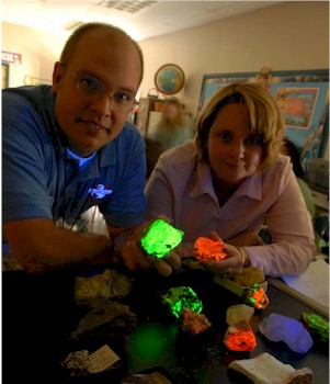 K-12 Fellow Bryan Schultz and Teacher-Partner Crystal Yates with rock samples that glow in ultraviolet light. Students did not find glowing rocks in their schoolyard soil pits, but the rocks and soil they did find provided information about the environmental history of the schoolyard.